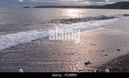 Evening sunlight creating a beautiful light over the ocean and beach in late summer Stock Photo