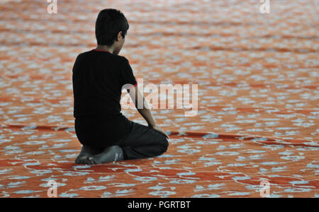 Young boy praying inside a mosque. Istambul, Turkey Stock Photo