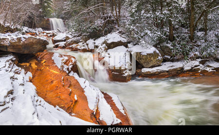 Winter visits Douglas Falls in Thomas, West Virginia, with a layer of snow covering the orange, iron laden sandstone created from acid mine drainage. Stock Photo