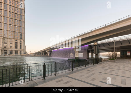 The Dubai Water Canal waterfall, where the canal meets Sheikh Zayed Road, during the day, Dubai, UAE Stock Photo