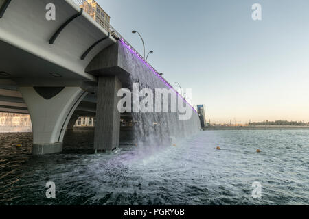 The  Dubai Water Canal waterfall, where the canal meets Sheikh Zayed Road, during the day, Dubai, UAE Stock Photo