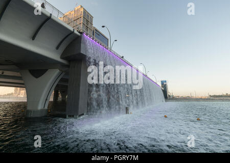 The  Dubai Water Canal waterfall, where the canal meets Sheikh Zayed Road, during the day, Dubai, UAE Stock Photo