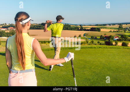 Professional golfer standing in the finish position of long drive shot Stock Photo