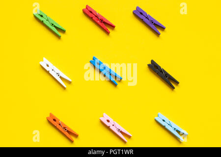 Nine colored clothespins on a yellow background Stock Photo