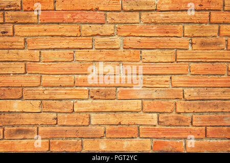 Ancient small block wall with brown and orange tone, Old square pattern, Texture background. Stock Photo