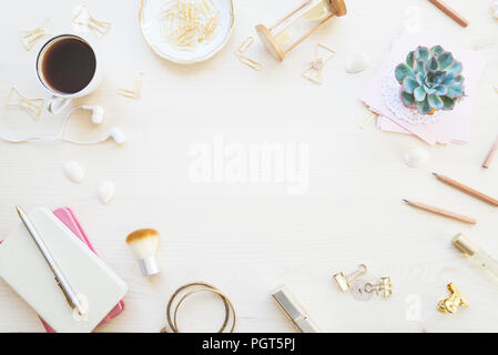 Female home office desk table in golden tones. Workspace with notebooks, cup of coffe, succulent and decorations on light wooden background with copy- Stock Photo