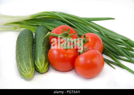 Tomatoes on a branch and cucumbers and greens isolated on white background. Vegetables on a white background. Food . Healthy eating. Vegetarianism Stock Photo