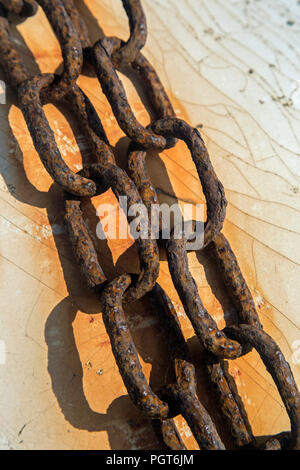 Two very rusty chains on a background of crackled white painted wood Stock Photo