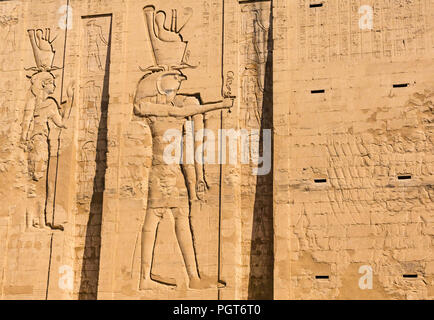 Egyptian carved figure hieroglyphs on entrance pylon of Temple of Horus, Edfu, Egypt, Africa Stock Photo