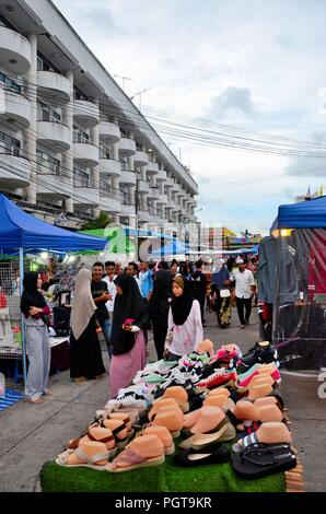 Crowds of people hang around outdoor street market shops & food stalls Pattani Thailand Stock Photo