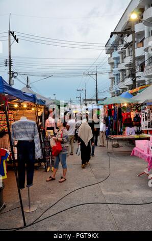 Crowds of people hang around outdoor street market shops & food stalls Pattani Thailand Stock Photo