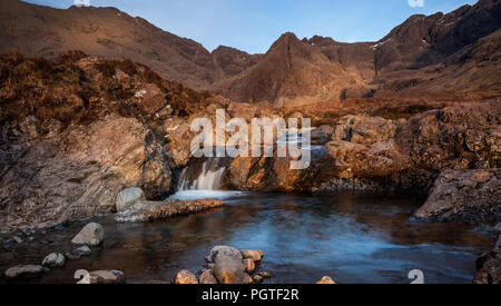 Located in Glen Brittle on the Isle of Skye lies the Fairy Pools a popular tourist attraction with the Cuillin Ridge in the background Stock Photo
