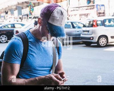 Tourist in a baseball cap and with a backpack Stock Photo