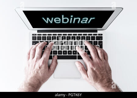 top view of laptop computer with word webinar on screen Stock Photo