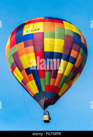 Multi-coloured balloon in a clear blue sky over the Bristol balloon fiesta, England