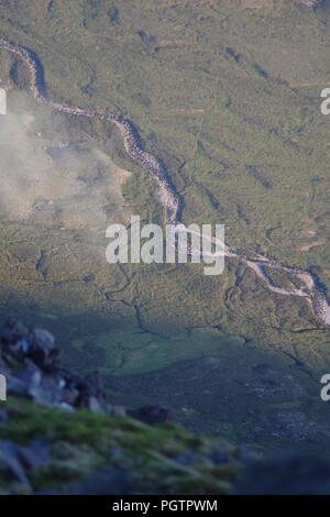 Meandering Burn Stream along the Valley Floor Under Slight Cloud Inversion. Birds Eye View from Meall a'Ghiubhais Mountain. Kinlochewe, Torridon, UK. Stock Photo