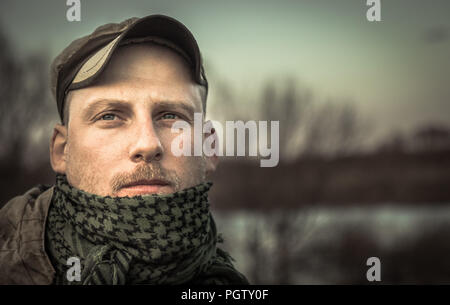 Pensive brutal thoughtful man soldier looking into the distance grunge portrait Stock Photo