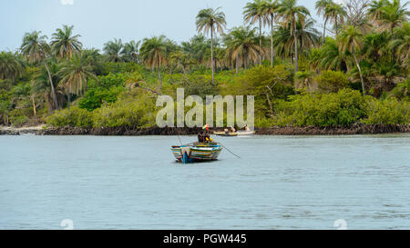 SOGA, GUINEA BISSAU - MAY 5, 2017: Unidentified local man sails in the boat on the coast of the Soga island, part of the Bijagos Archipelago Stock Photo