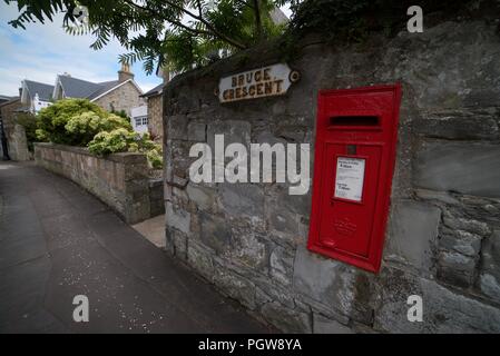 Red Post Box on a wall on a British Street Stock Photo