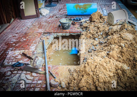 Underground PVC pipe of the water supply is broken and being repaired by the plumber. Stock Photo