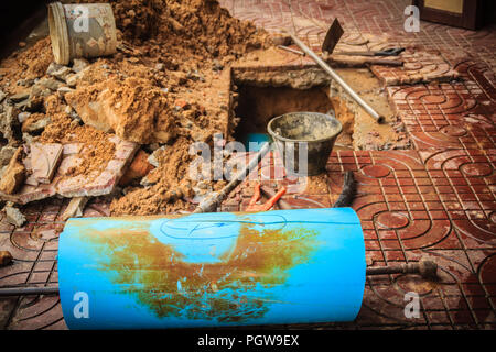 Underground PVC pipe of the water supply is broken and being repaired by the plumber. Stock Photo