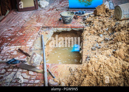 Underground PVC pipe of the water supply is broken and being repaired by the plumber. Stock Photo