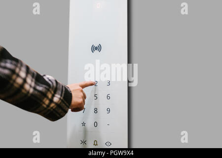 Close-up of a girl pressing a touch button in a modern elevator. Stock Photo