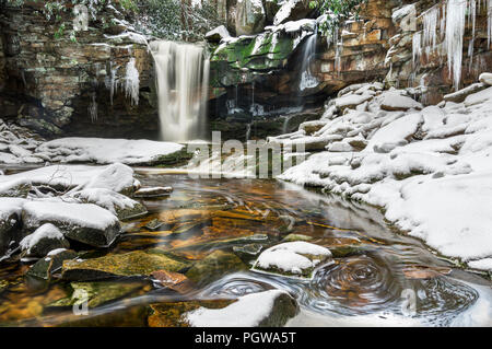 Snow contrasts with the golden, tannin rich waters of Shays Run, or Elakala Falls in Blackwater Falls State Park, West Virginia. Stock Photo