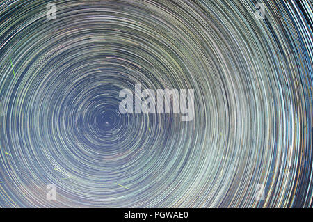 A long exposure captures the rotation of the Earth with a full frame image of the stars circling the North Star, Polaris over a long period of time. Stock Photo