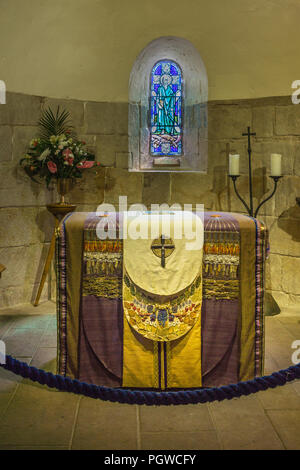 Edinburgh, Scotland, UK - June 14, 2012: Draped altar and Stained Glass Window of St Andrew behind at St Margareth Chapel with flowers and candles. Stock Photo
