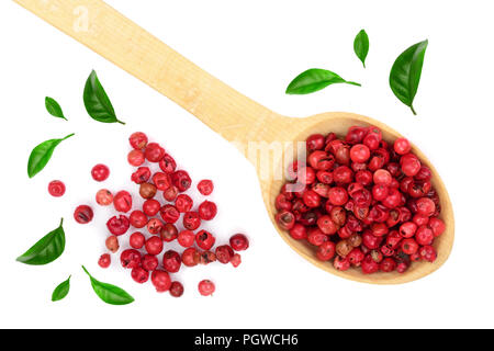 red peppercorns seeds in wooden spoon decorated with green leaves isolated on white background. Top view. Flat lay Stock Photo