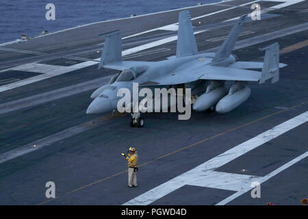 180823-N-NN369-1155 ATLANTIC OCEAN (Aug. 23, 2018) Chief Aviation Boatswain's Mate (Handling) William Sum directs an F/A-18E Super Hornet from the Pukin' Dogs of Strike Fighter Squadron (VFA) 143 on the flight deck of the Nimitz-class aircraft carrier USS Abraham Lincoln (CVN 72). (U.S. Navy photo by Mass Communication Specialist 2nd Class Jessica Paulauskas/Released) Stock Photo