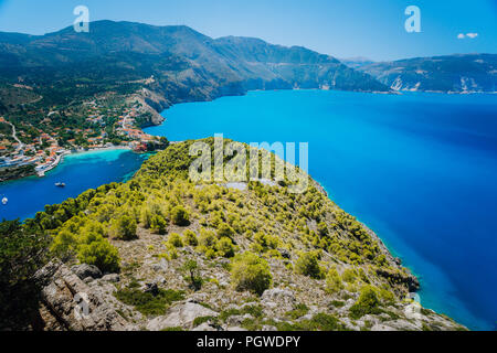 Ultra wide shot of Assos village in morning light, Kefalonia. Greece. Beautiful turquoise colored bay lagoon water surrounded by pine and cypress trees along the coastline Stock Photo