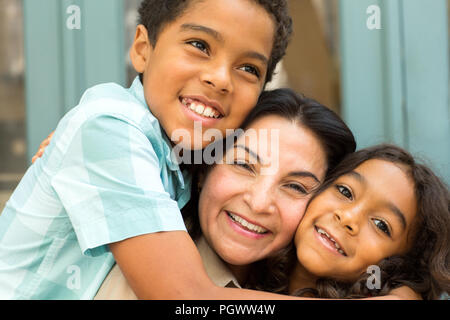 Happy Hispnaic mother laughing and talking with her children. Stock Photo