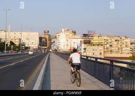 Man cycling across the Branko Bridge, toward the old town of Belgrade, Serbia. Stock Photo