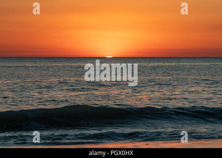 An orange sunset on a clear night over the ocean in Perth Western Australia Stock Photo
