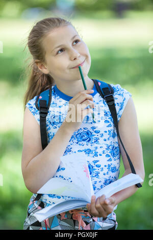 Pretty young Caucasian girl makes sketches of landscapes in nature with color pencil Stock Photo