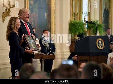 President Donald J. Trump presenting the Medal of Honor to Valerie Nessel, the spouse of U.S. Air Force Tech, August 22, 2018. Sgt. John Chapman, at the Medal of Honor ceremony, White House, Washington, D.C. Image courtesy Wayne Clark / Secretary of the Air Force Public Affairs. () Stock Photo