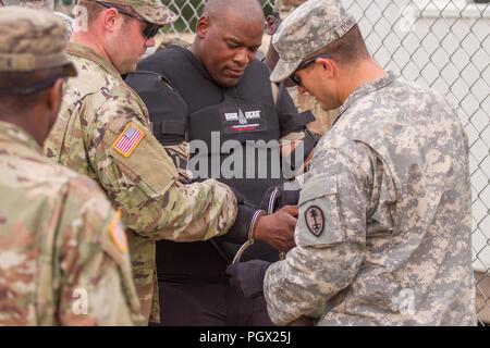 U.S. Army Military Police Soldiers securing a detainee with handcuffs, role-played by Sgt. 1st Class Marcus Brown, during Combat Support Training Exercise (CSTX) at Fort McCoy, Wisconsin, August 20, 2018. Image courtesy Spc. Cody Hein / 86th Training Division. () Stock Photo