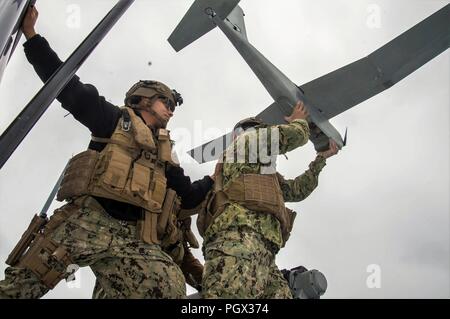 PACIFIC OCEAN (June 19, 2018) Chief Boatswain’s Mate Thania Shirley holds Engineman 2nd Class Bryson Isaac Ostrander both assigned to Coastal Riverine Squadron (CRS) 3 during the launch of the unmanned aerial vehicle (UAV) aboard MKVI patrol boat during the UAV training exercise conducted by Coastal Riverine Group (CRG) 1 Training and Evaluation Unit. CRG provides a core capability to defend designated high value assets throughout the green and blue-water environment and providing deployable Adaptive Force Packages (AFP) worldwide in an integrated, joint and combined theater of operations. Stock Photo
