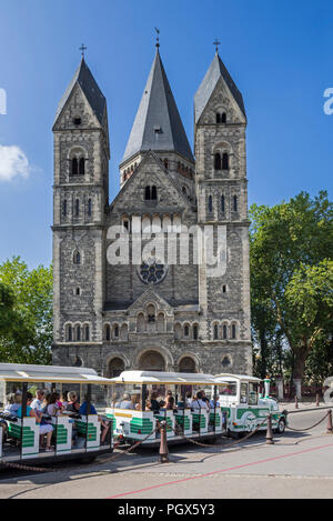 Tourists in little tourist train in front of the Temple neuf, Neo-Romanesque Protestant Reformed Church in the city Metz, Moselle, Lorraine, France Stock Photo