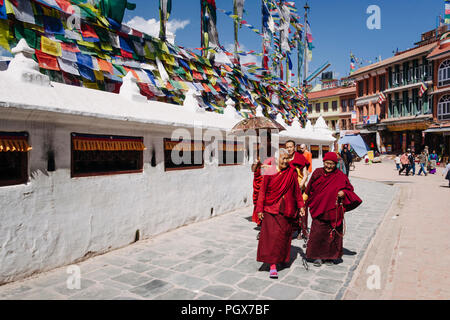 Bodhnath , Kathmandu, Bagmati, Nepal : Buddhist monks and nuns in maroon robes walk around the Great stupa of Bodhnath, the largest in Asia and one of Stock Photo