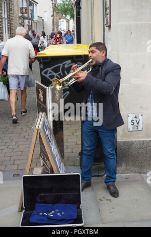 Man playing a trumpet on the high street in Wells, Somerset, UK Stock Photo