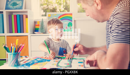 Little child drawing on the paper with father Stock Photo