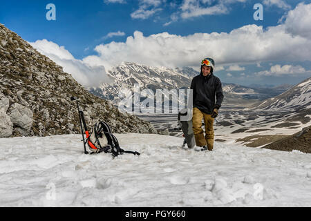 A freeride snowboarder come back after his jump. In the background, an amazing view of the Gran Sasso massif Stock Photo