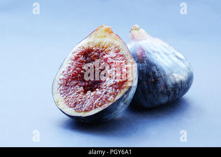 Figs whole and sliced on gray background Stock Photo