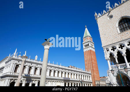 San Marco bell tower, lion statue and Doge palace wide angle view, clear blue sky in Venice, Italy Stock Photo