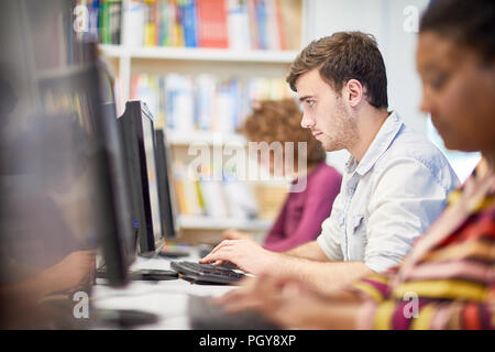 Concentrated young man working on computer at university Stock Photo