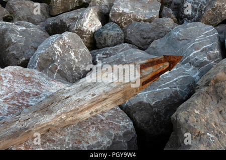 Washed up wooden groyne and rock armour, East Lane, Bawdsey, Suffolk, UK. Stock Photo