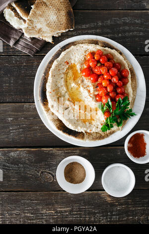 Chickpea hummus served on flatbread with cherry tomatoes, top view Stock Photo